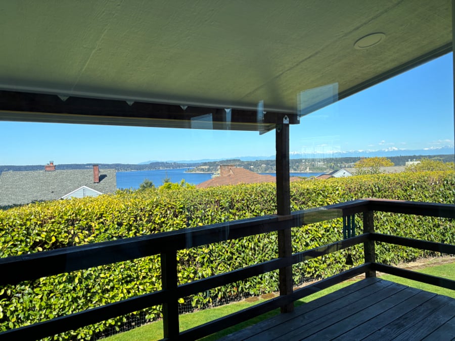 View from the deck, which can be directly accessed from the primary bedroom. You can see the water and Olympic Mountains on a sunny day.