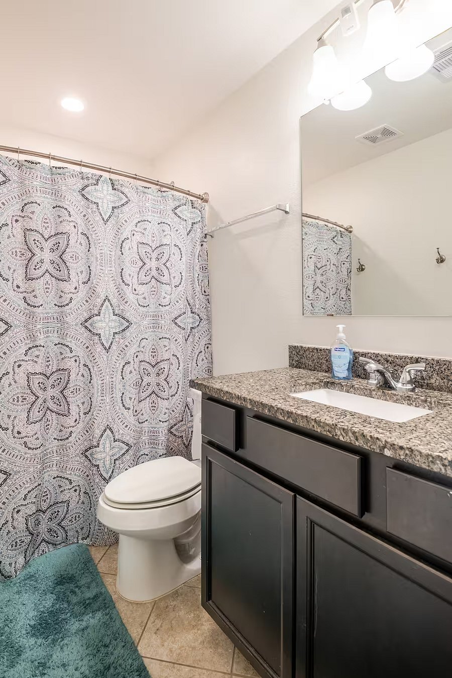 Shared bathroom with built-in storage, a curved shower rod, and a few extra comfort touches.