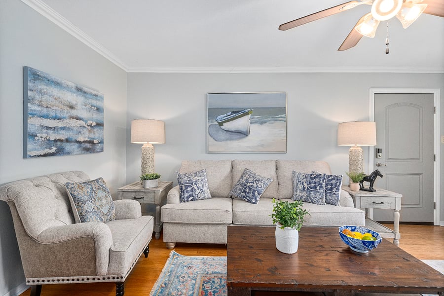 Living room with large windows to bring in alot of light. Full size sofa, plus loveseat. Smart TV mounted above the fireplace mantle.