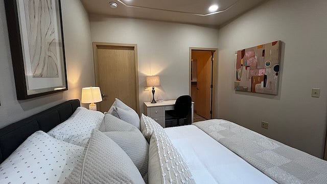 Bedroom 1.
With walk in closet, attached bath, queen bed, desk, and outside balcony.