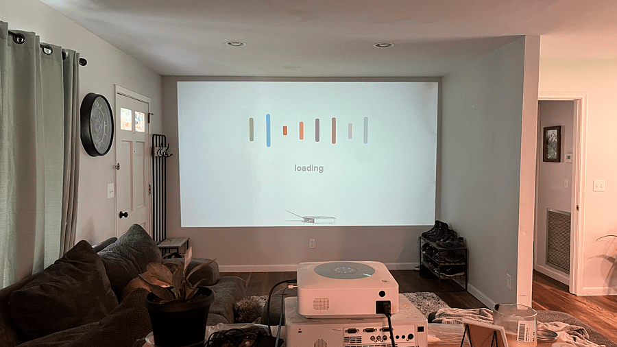 Living room with wrap-around couch and projector for tv
