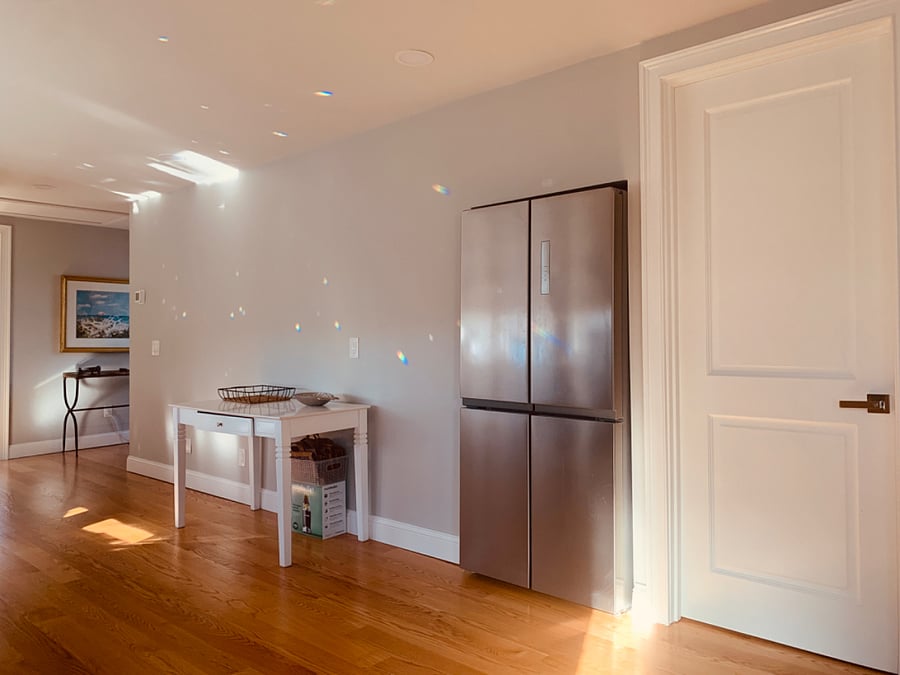 Full refrigerator with freezer below. East bedroom door to the right.