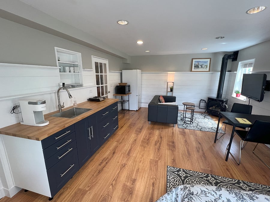 View of kitchen space, living space and doorway leading to closet space and bathroom