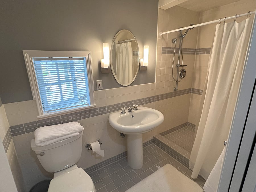 Spacious bathroom with stand up shower and large mirror