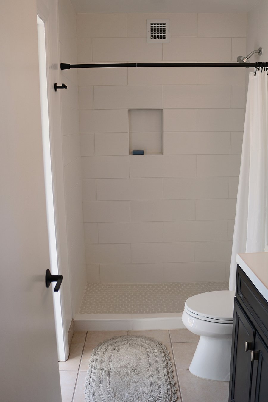 primary bedroom en suite bathroom with door exiting to backyard