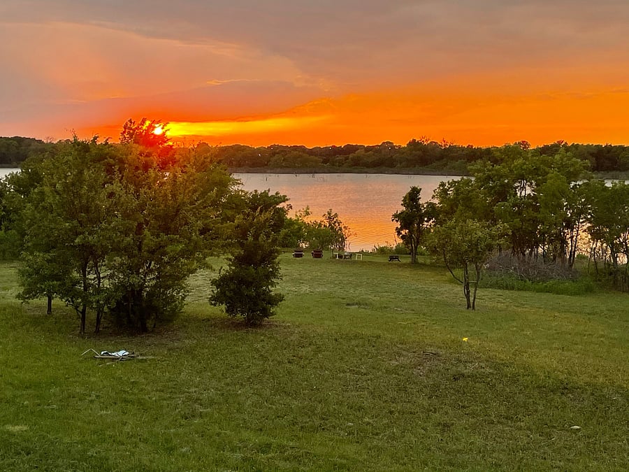 Enjoy a covered back ground level deck with dining area, seating for sunsets across the lake. The home is at 10 feet above ground level over the Corps of Engineers property of Lake Lewisville. 