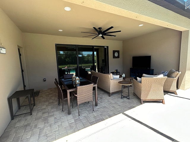Shaded under truss area with dining table and comfortable seating area with tv.