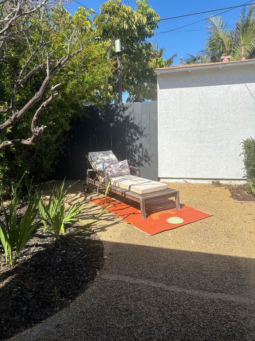 Large backyard with lounge chair.