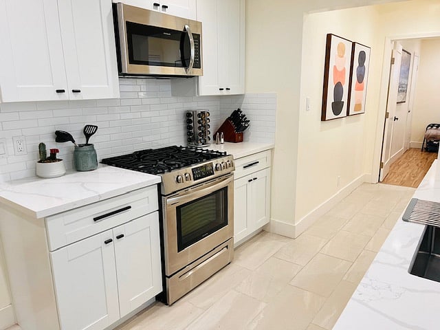 Full kitchen with gas range and stove, Frigidaire dishwasher, sink with garbage disposal, microwave, and full Refrigerator with freezer and ice maker. Home comes furnished with spice rack, coffee maker, pots pans and essential items for cooking and dining.