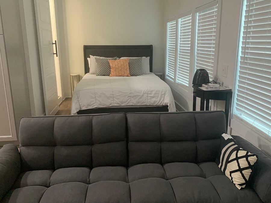 View of bedroom area with queen size bed, night stands, bed has usb as part of the headboard for charging devices while sleeping.