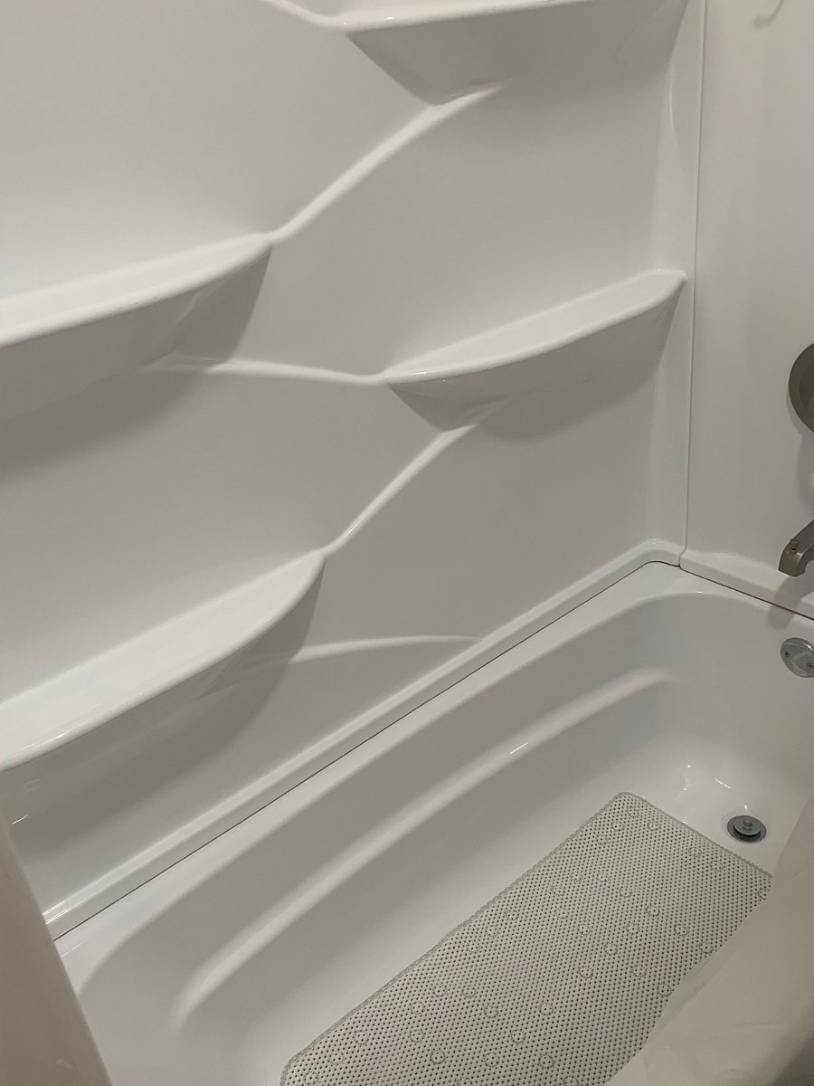 Large shower/ tub area with lots of storage for hair and bathing products.