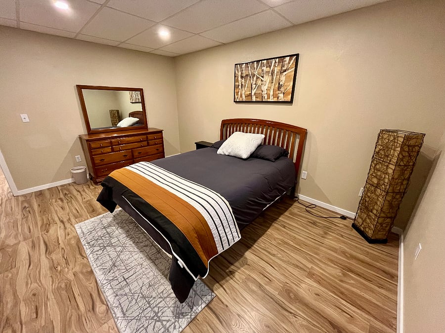 2nd room - queen sized bed, dresser, bedside table, and lamp.