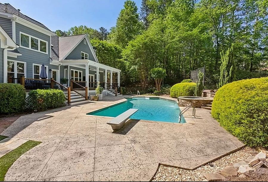 Pool in backyard next to hot tub and tennis courtar