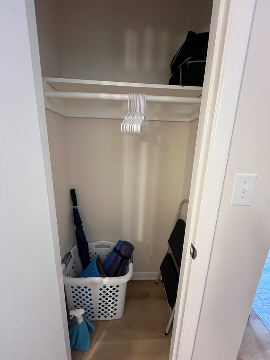 Downstairs coat closet with golf umbrella and yoga equipment.