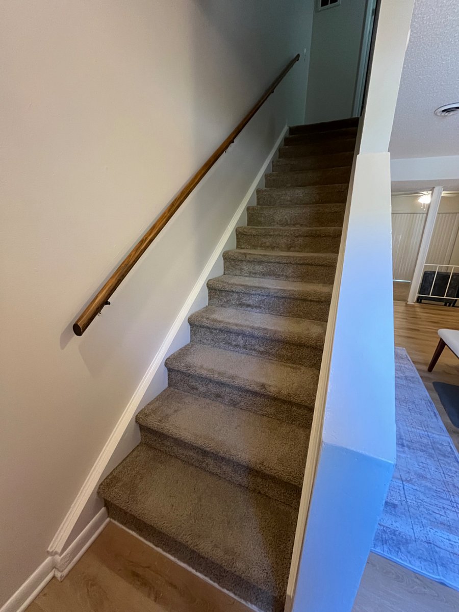 Stairway inside the unit leading upstairs to the two bedrooms, full bath, laundry area, and closets.