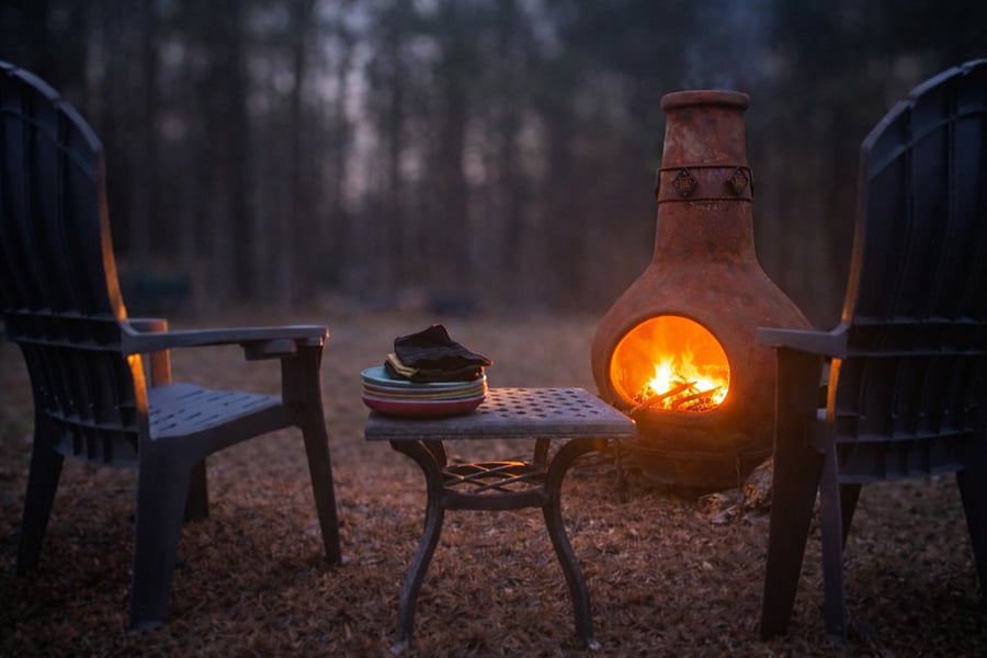 Unwind by the fire: Enjoy quiet evenings by the chiminea with comfortable seating, warm firelight, and peaceful wooded surroundings perfect for relaxing after a long day.