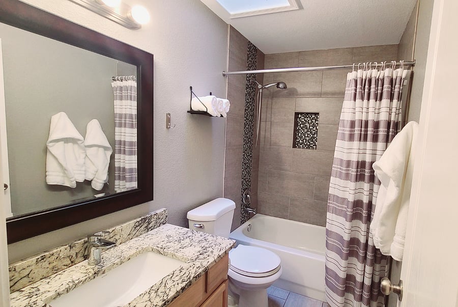 Experience comfort in our spacious second bathroom, complete with a tub/shower combination. The skylight adds a cozy touch, filling the space with natural light throughout the day.