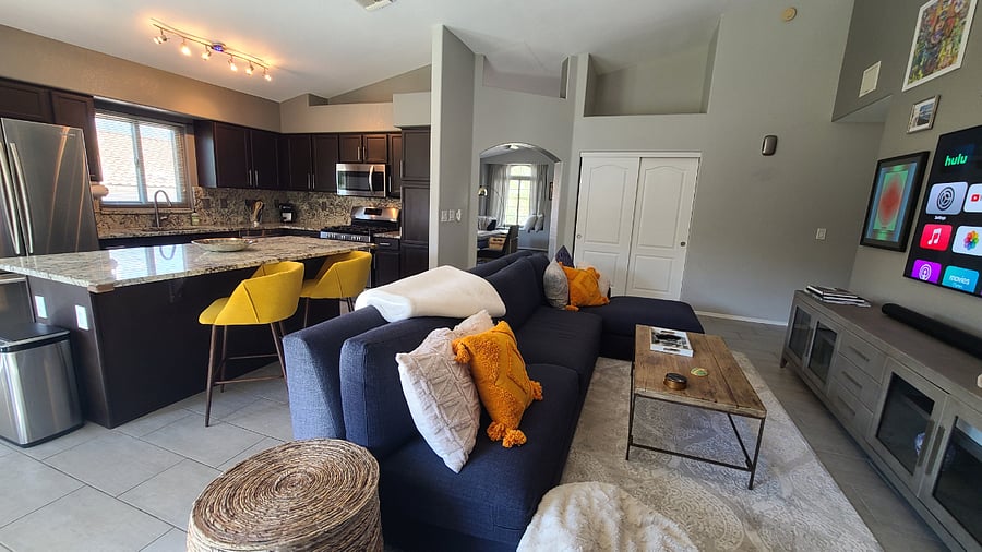 The spacious kitchen beckons culinary adventures, allowing you to prepare a delicious meal while still engaging with family and friends. The seamless flow from the kitchen to the cozy sectional invites relaxation & shared moments.