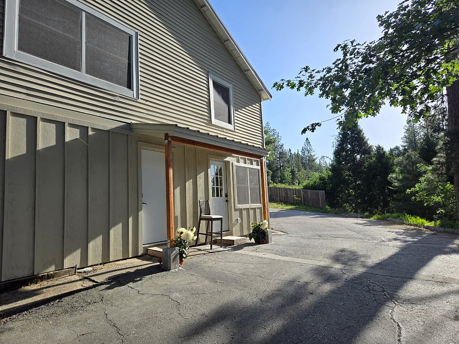 Sudio B is entered on the right door and the laundry room is accessed through the left door.  You can see the forested vacant lot behind the house.  Your parking spot is directly across from your front door against the fence.