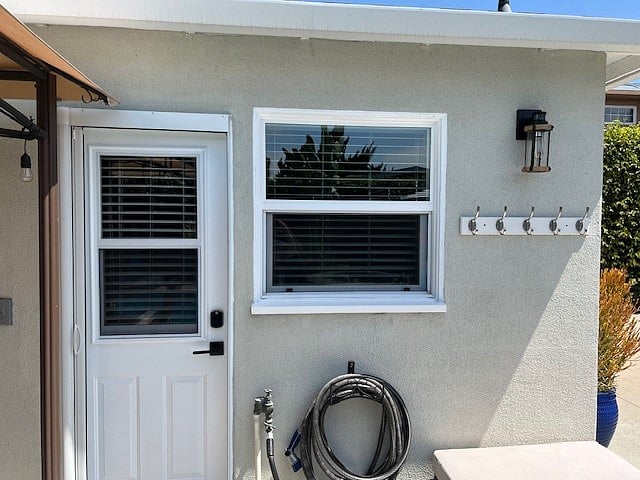 Front Door to Bungalow with keypad entrance and kitchen window.