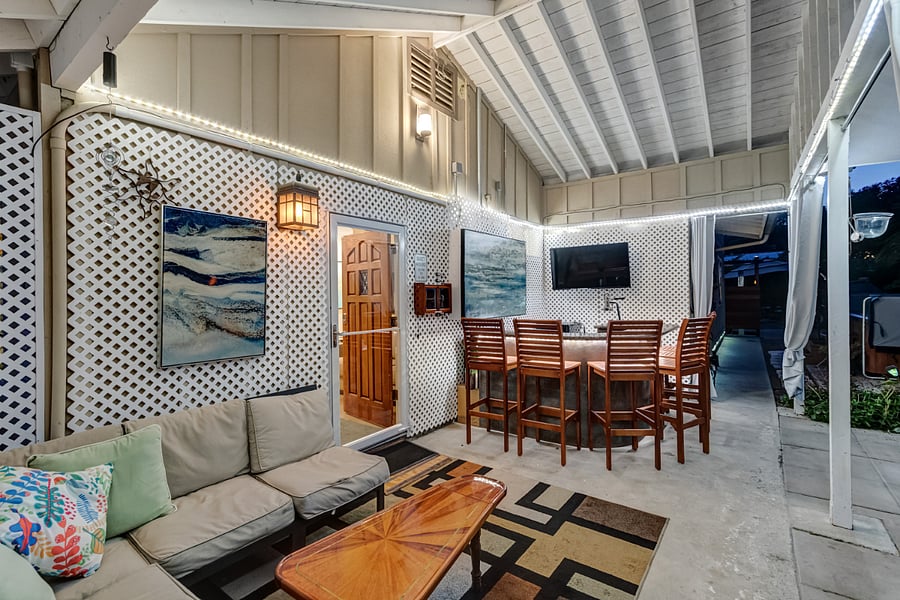 Outdoor bar has a lounge, bar, smart TV, wine rack, beverage refrigerators and ink and bar.
