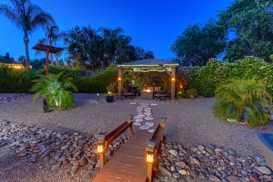 Transition from the outdoor dining patio to the gazebo and its inviting fire pit.