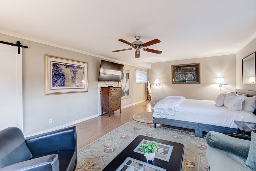 The master bedroom offers generous space, featuring a king-sized bed adorned with luxury linens. It also includes a smart TV, a lounge area with a futon couch, and a nursery for your convenience.