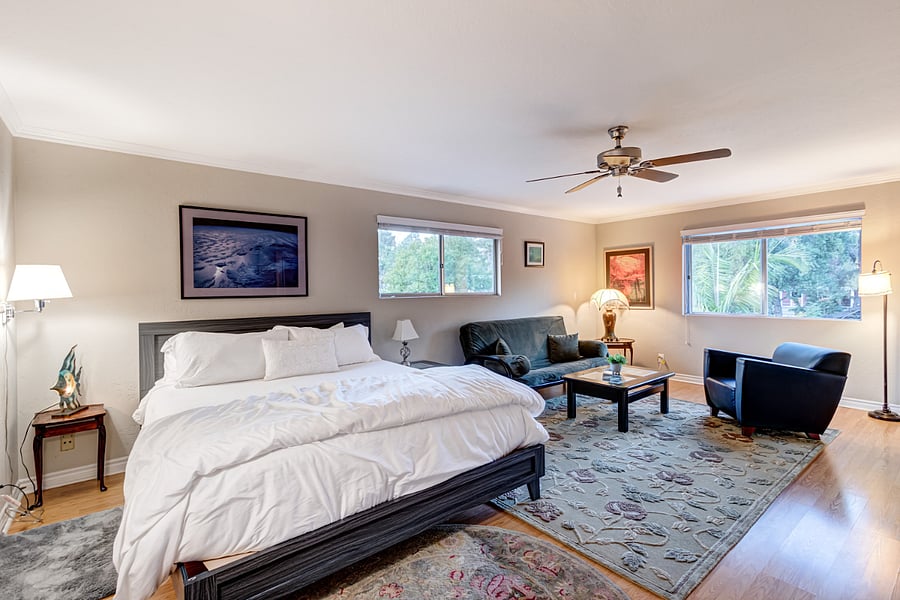 The master bedroom offers generous space, featuring a king-sized bed adorned with luxury linens. It also includes a smart TV, a lounge area with a futon couch, and a nursery for your convenience.