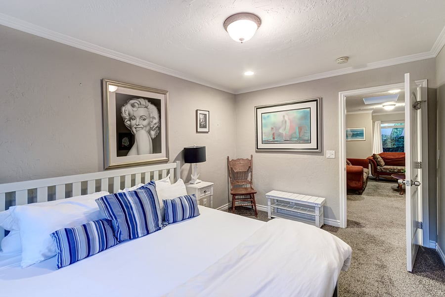 Bedroom 4 features a walk-in closet stocked with additional sleeping supplies such as blow-up mattresses, pillows, and blankets. The room itself boasts a king bed adorned with luxury linens for utmost comfort.