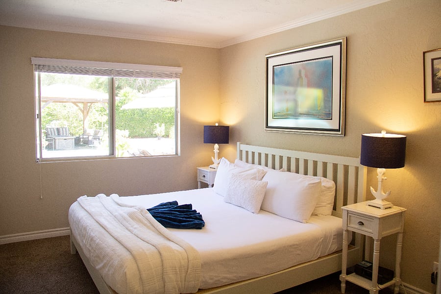 Bedroom 4 features a walk-in closet stocked with additional sleeping supplies such as blow-up mattresses, pillows, and blankets. The room itself boasts a king bed adorned with luxury linens for utmost comfort.