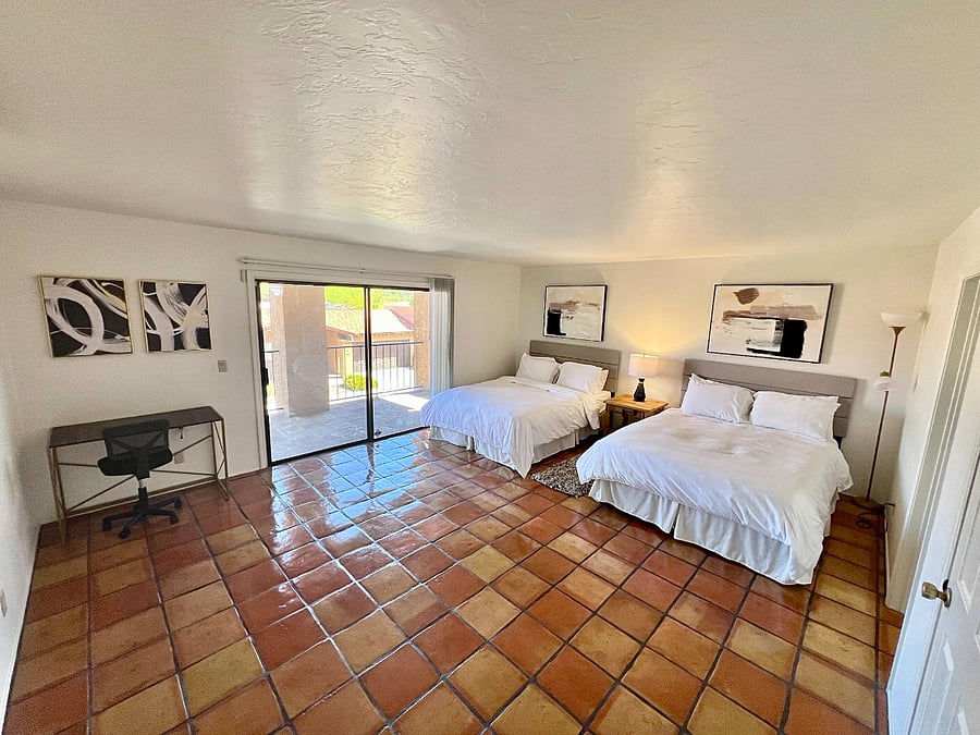 Upstairs bedroom with 2 queen beds, balcony, and ensuite bathroom