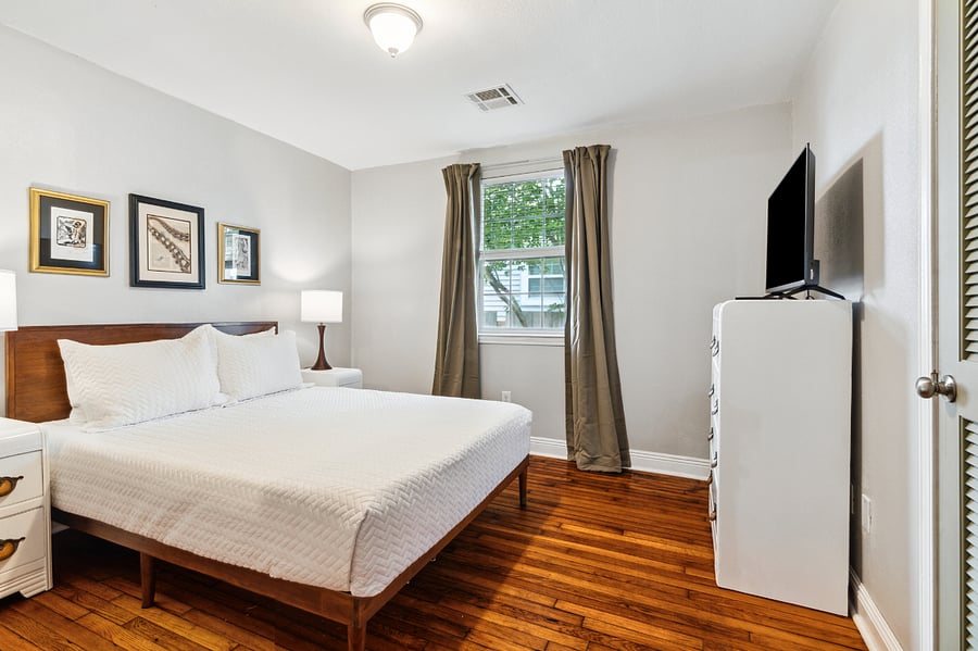 This Queen bedroom features a closet and dresser for added storage, a smart tv, and an un-pictured mirror.