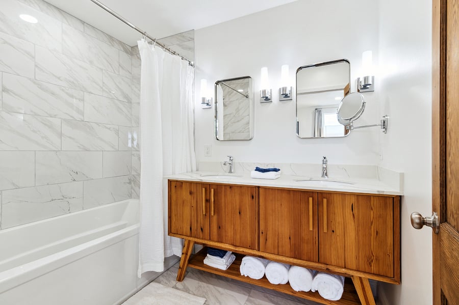 The primary en-suite bathroom features a duel vanity, soaking tub, and divider between the toilet for added privacy.