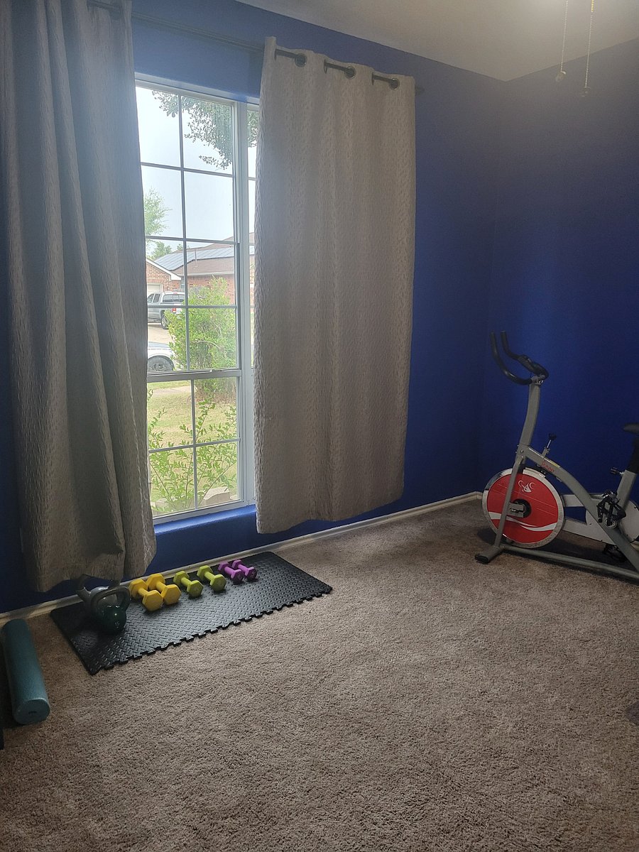 Weights stationary bike office room natural sunlight