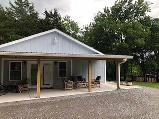 Front porch with tree lined area. Great for watching deer and listening to the rain on the metal roof covered porch with fan