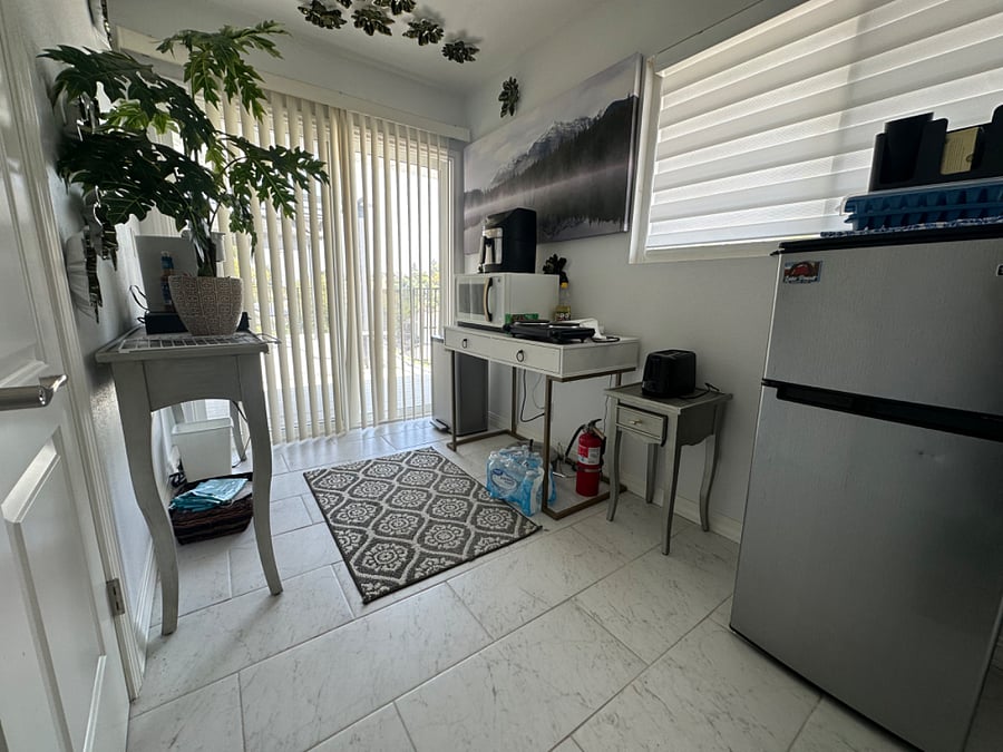 Bachelor kitchen with coffee machine, stove top, air fryer, fridge, ice machine, and microwave.