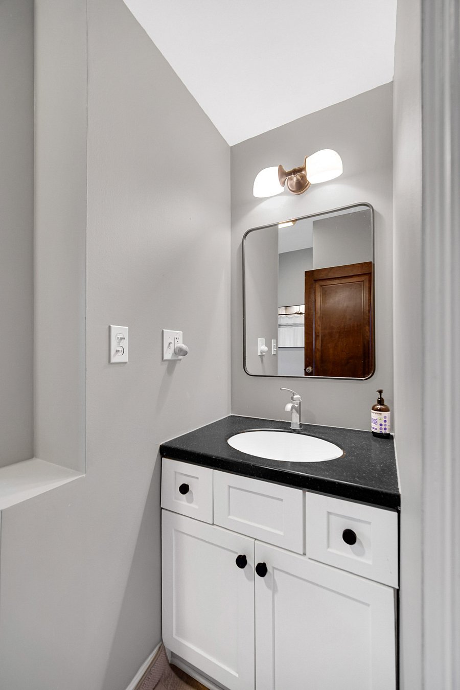 Hallway bathroom between the King and Twin bedrooms. Sink with storage underneath, handicap accessible shower and toilet. 