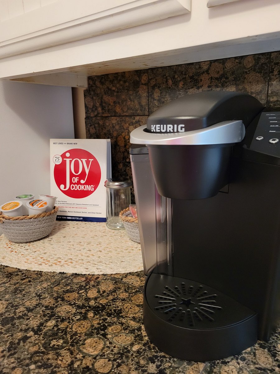 Keurig machine with starter coffee pods, creamer and sugar.
