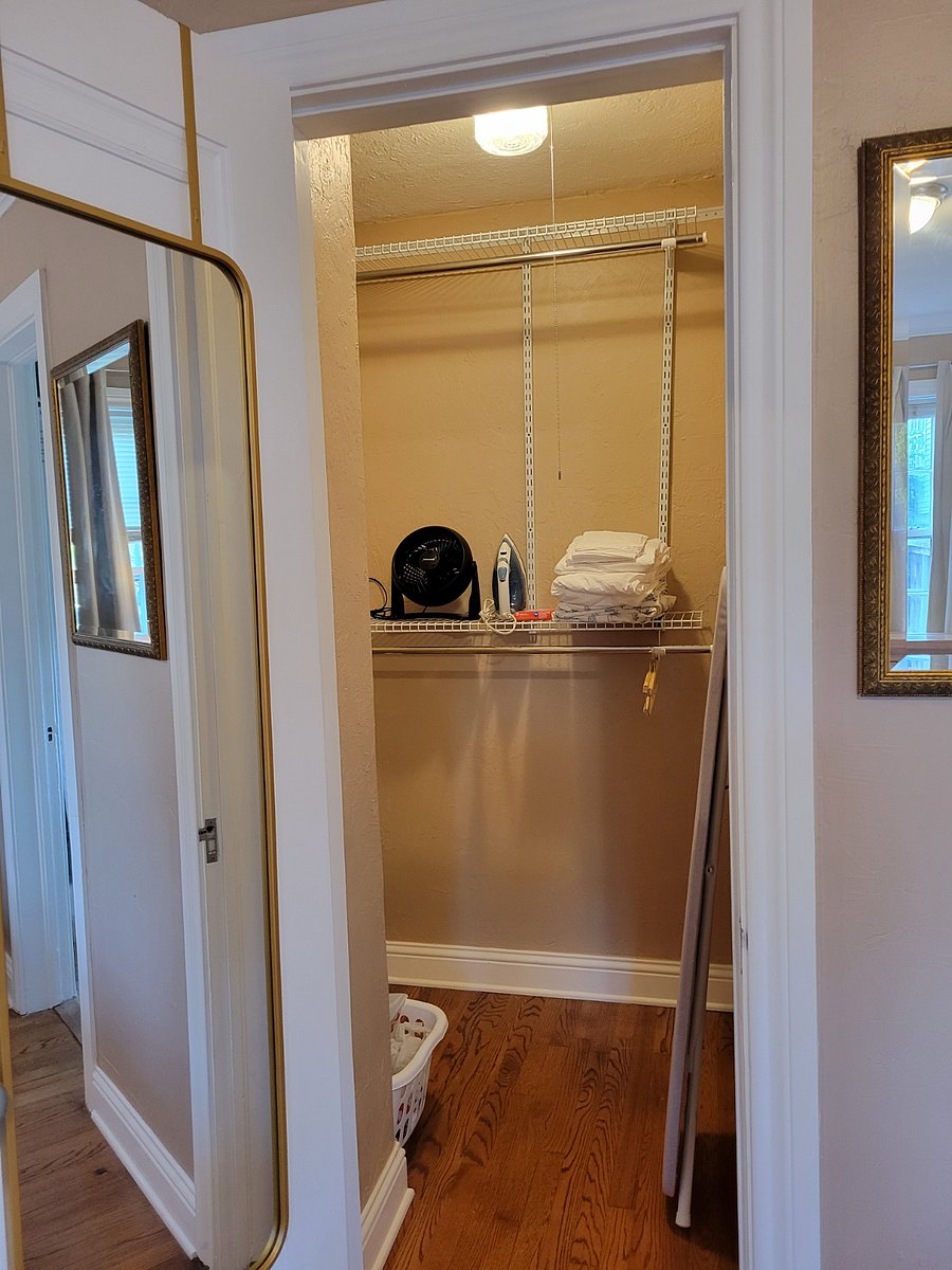 Large walk-in closet. Iron, fan, extra bed linens, iron board, hangers, vacuum, broom, dust mop.