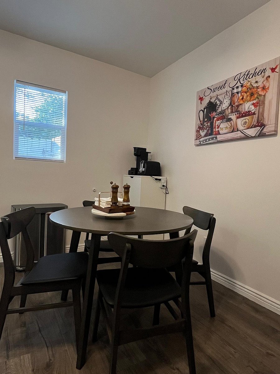 Dining area with starter napkins and a starter salt and pepper set. Dining room is connected to living room and kitchen.
