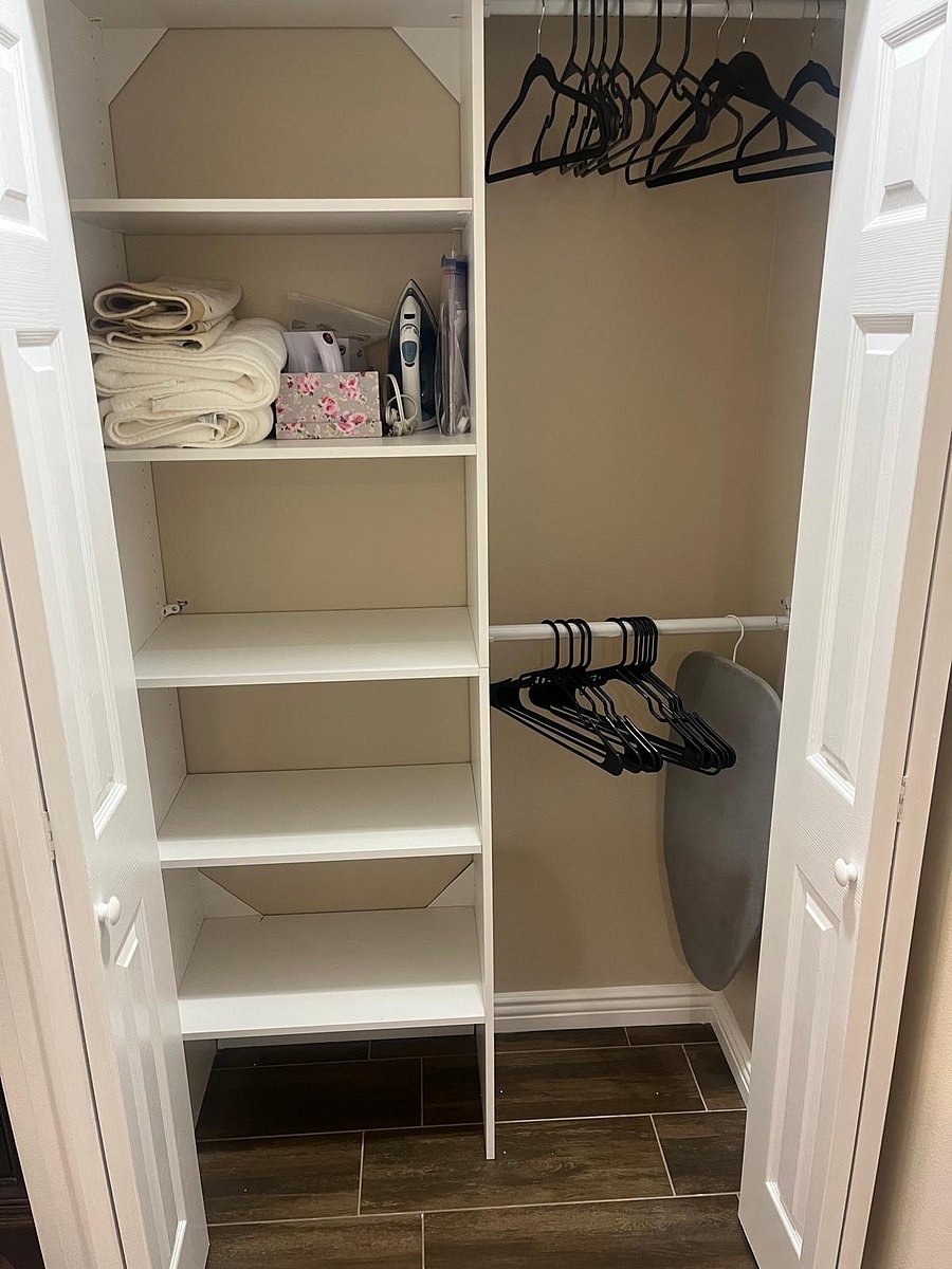 Small closet next to bathroom. Small ironing board, clothes iron, steamer, and hangers available. 