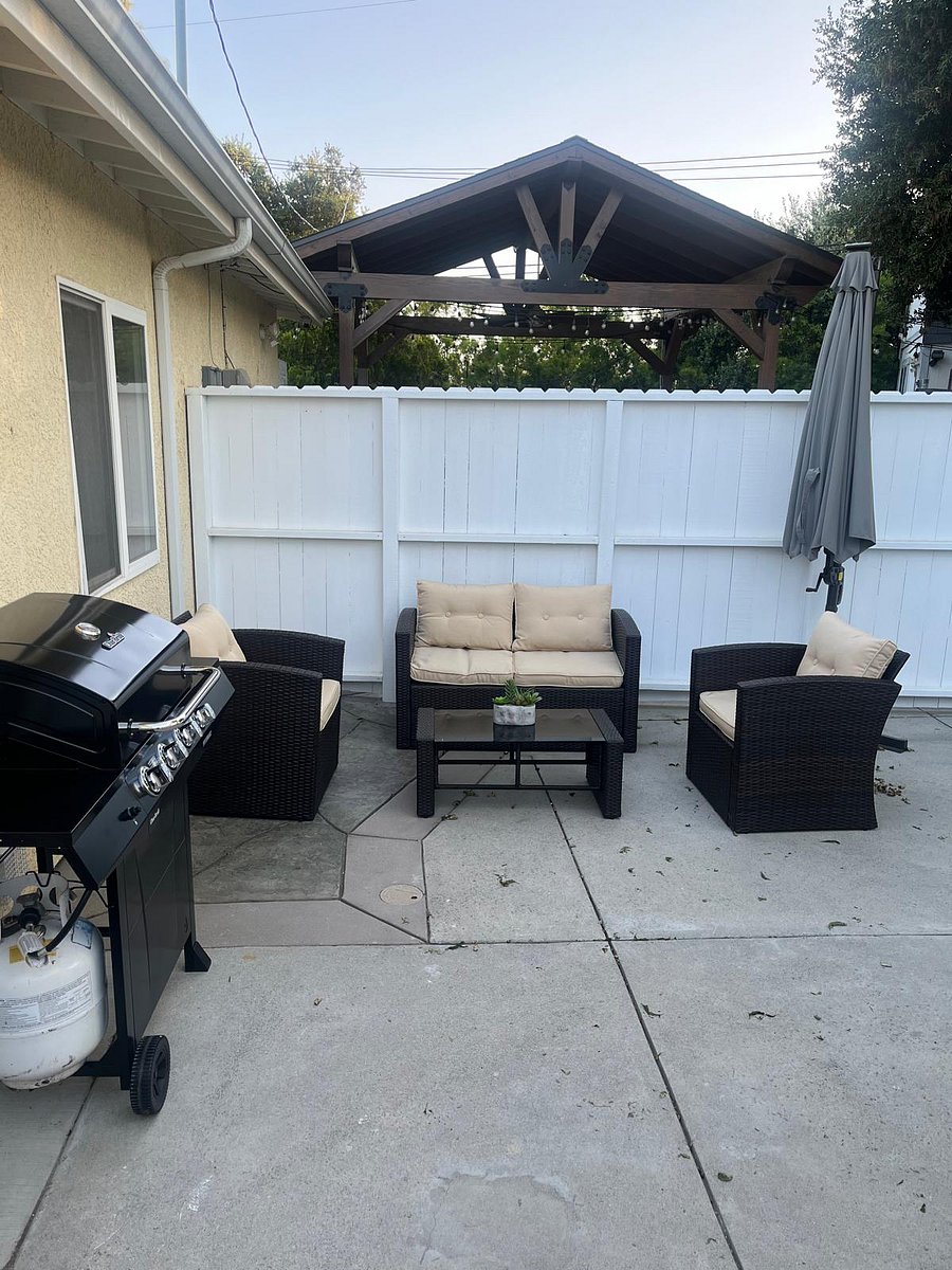Backyard with seating area and grill with starter tank of gas. 