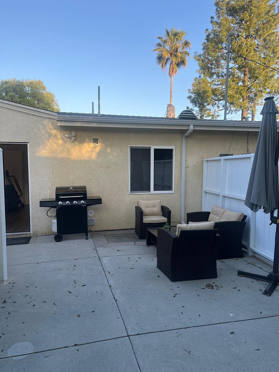 Backyard with seating area and grill with starter tank of gas. 