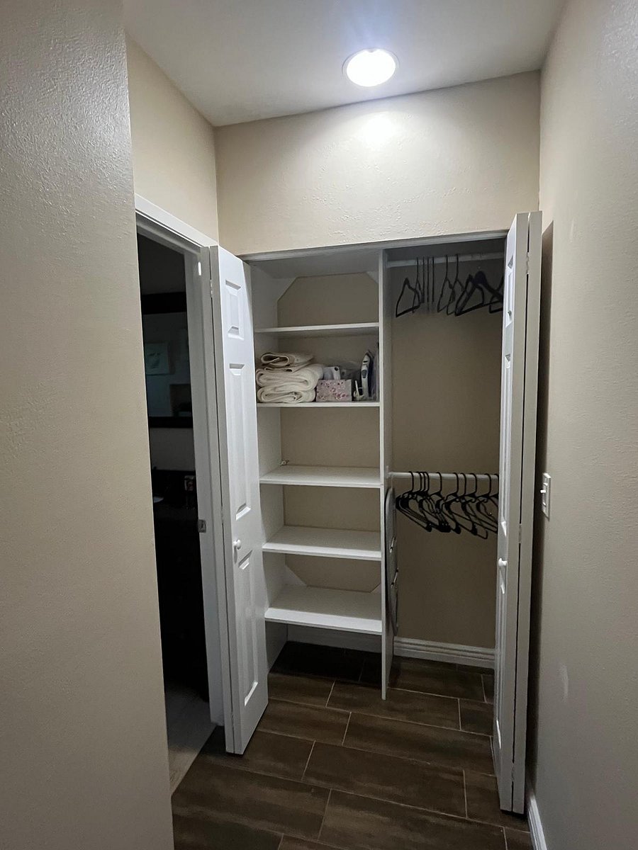 Small closet next to Bathroom. Small ironing board, clothes iron, steamer, and hangers available.
