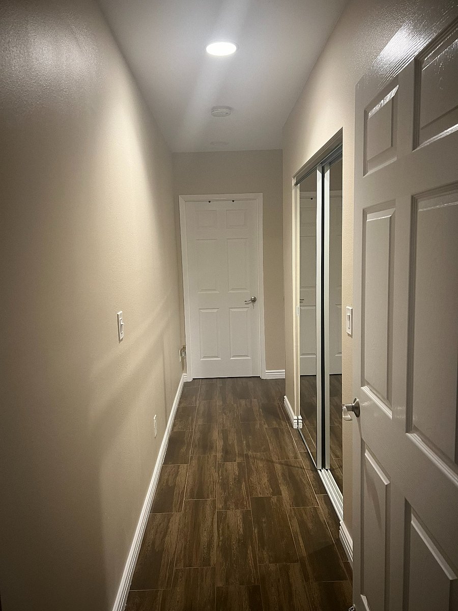 Hallway from living room/dining/kitchen area to Bedrooms. Door in picture leads to bedroom of one to two roommates.