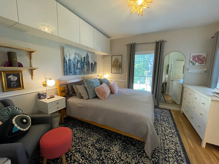 Primary bedroom with king bed, firm memory foam mattress, desk, sitting area, dresser, TV, walk-in closet, additional wall cabinet storage, and fully renovated (2024) ensuite bathroom