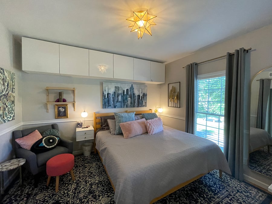 Primary bedroom with king bed, firm memory foam mattress, desk, sitting area, dresser, TV, walk-in closet, additional wall cabinet storage, and fully renovated (2024) ensuite bathroom