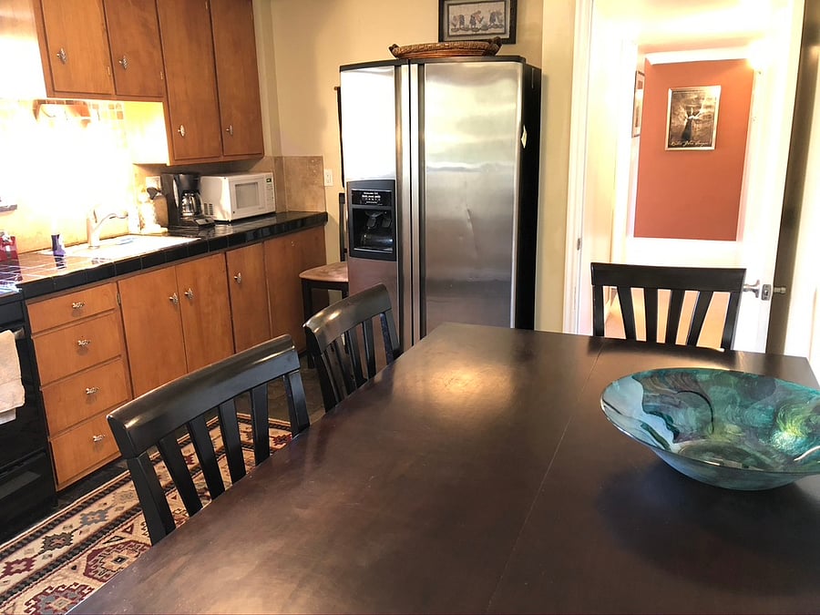 Full-size stainless steel fridge and 6-person dining table
