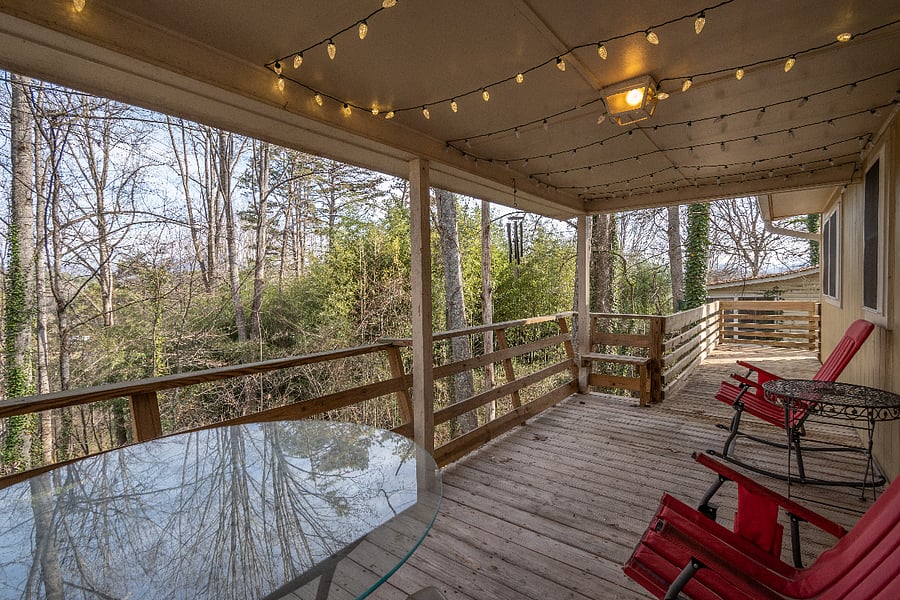 Outdoor deck with seating and fairy lights for night time.
