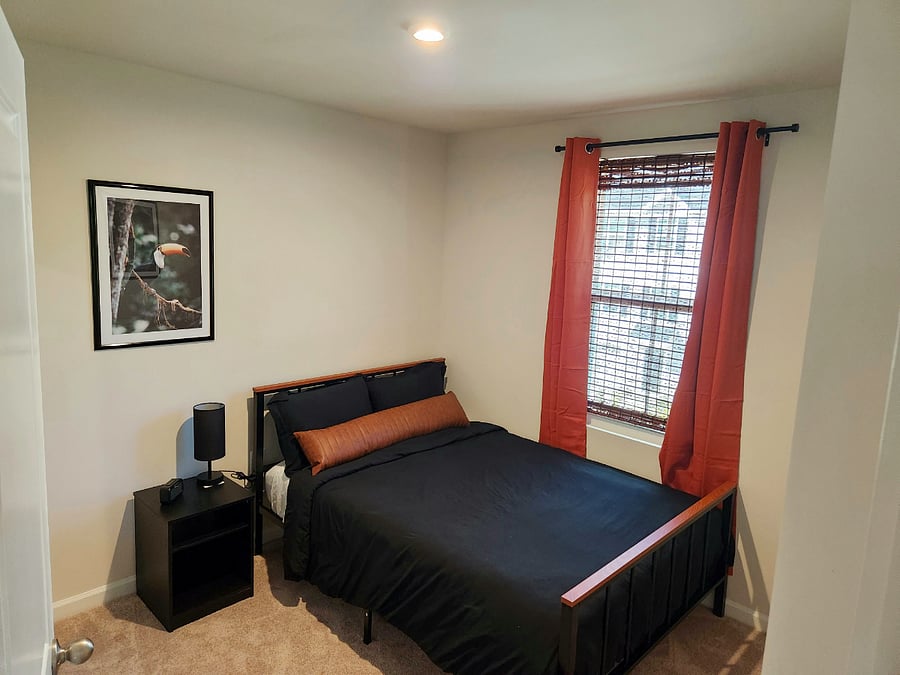 Full-sized bed with memory foam mattress and adjustable lamp located in guestroom